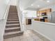 Carpeted staircase with white railings and kitchen view at 10135 Post Harvest Dr, Riverview, FL 33578