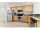 Modern kitchen with stainless steel appliances and light wood cabinets at 11605 Gulf Blvd # 507, Treasure Island, FL 33706