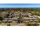 Aerial view of Villas de Golf community, showing buildings, pool, tennis court, and surrounding landscape at 12300 Vonn Rd # 9205, Largo, FL 33774