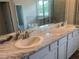 Modern bathroom featuring a double vanity with marble countertops, stylish fixtures, and lots of natural light at 16030 10Th E Ave, Bradenton, FL 34212