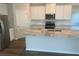 Modern kitchen with white cabinets, a large marble island, stainless steel appliances, and hardwood flooring at 16030 10Th E Ave, Bradenton, FL 34212