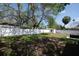 Backyard with large grassy area, white vinyl fence, and storage shed at 1779 Shore Acres Ne Blvd, St Petersburg, FL 33703