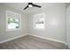 Well-lit bedroom with gray flooring and two windows at 1779 Shore Acres Ne Blvd, St Petersburg, FL 33703