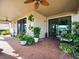 Covered patio featuring brick pavers, ceiling fans, outdoor seating and lush plants at 19757 Long Lake Ranch Blvd, Lutz, FL 33558