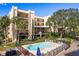 Condo complex with a refreshing blue pool and lounge chairs at 206 Tarpon Pt, Tarpon Springs, FL 34689