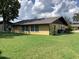 Rear view of the house showcasing a large backyard and a brown roof at 31204 Lancewood Dr, Brooksville, FL 34602