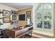 Home office features a large desk, comfortable chair, and an arched window at 3398 Pinnacle S Ct, Palm Harbor, FL 34684