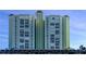 Tall residential building with many balconies and parking below at 400 64 Ave # 1207, St Pete Beach, FL 33706