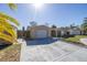 Single-story home with a long driveway and palm trees at 7430 Buchanan Dr, Port Richey, FL 34668