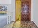 Front entrance with a dark wood door and glass sidelight at 7430 Buchanan Dr, Port Richey, FL 34668