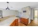 Kitchen with wood cabinets, white appliances, and stone accent wall at 7430 Buchanan Dr, Port Richey, FL 34668