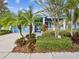 Front view of a charming light blue house with palm trees and lush landscaping at 509 Manns Harbor Dr, Apollo Beach, FL 33572