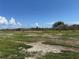 Sprawling backyard with an open field and scattered trees under a bright blue sky at 3960 Headsail Dr, New Port Richey, FL 34652