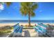 Inviting beach benches with blue and white accents, offering a scenic view of the ocean and tropical landscape at 3960 Headsail Dr, New Port Richey, FL 34652