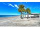 Wide beach with palm trees and beach canopies for shade at 3960 Headsail Dr, New Port Richey, FL 34652