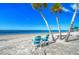 Relaxing beach scene with turquoise chairs, palm trees, and a serene ocean view, perfect for vacation at 3960 Headsail Dr, New Port Richey, FL 34652