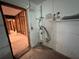 Corner of unfinished utility room, exposed studs, shelf with cleaning supplies at 3960 Headsail Dr, New Port Richey, FL 34652