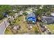 Exterior aerial showing a home with hurricane damage to the roof under a blue tarp on an overgrown lot at 8474 Tobay N Rd, St Petersburg, FL 33702