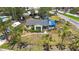 Aerial view of a one-story home with a gray roof, lush greenery, and a classic vintage truck nearby at 8474 Tobay N Rd, St Petersburg, FL 33702