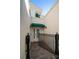 Private entryway with gate and green awning, leading to the front door at 921 Osceola Rd, Belleair, FL 33756
