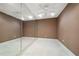 Mirrored exercise room with ceiling fan and light flooring at 921 Osceola Rd, Belleair, FL 33756