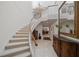 Elegant curved staircase with chandelier and ornate detailing in the foyer at 921 Osceola Rd, Belleair, FL 33756