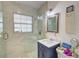 Updated bathroom with a walk-in shower, navy vanity, and decorative mirror at 1008 Chester Dr, Clearwater, FL 33756