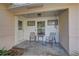 Relaxing front porch with stone tile flooring and a small table and chairs at 1008 Chester Dr, Clearwater, FL 33756