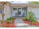 Inviting front porch with stone tile flooring and two comfy chairs at 1008 Chester Dr, Clearwater, FL 33756