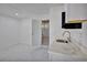 White kitchenette with stainless steel sink and marble floors at 1008 Chester Dr, Clearwater, FL 33756