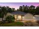 Well-maintained single Gathering home with a landscaped yard at dusk at 14649 Deacon Ct, Spring Hill, FL 34609