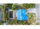 Aerial view of home with blue tarp covering roof and damaged pool at 16202 3Rd St E, Redington Beach, FL 33708