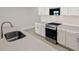 Modern kitchen featuring stainless steel appliances, white cabinets, and a center island with sink at 18424 Vista Park Ter, Venice, FL 34293