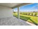 Covered patio area overlooking a large, meticulously maintained lawn with lush landscaping at 18424 Vista Park Ter, Venice, FL 34293