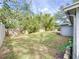 Fenced backyard with grassy area and mature trees at 2358 Havana Dr, Clearwater, FL 33764