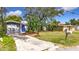 Newly renovated home with a blue door, fresh landscaping, and a large yard at 2358 Havana Dr, Clearwater, FL 33764
