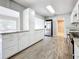 Modern kitchen featuring white cabinets and wood-look tile floors at 2358 Havana Dr, Clearwater, FL 33764
