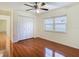 Bright bedroom with wood floors, ceiling fan, closet and a window overlooking the yard at 3612 Covington Dr, Holiday, FL 34691