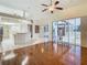 Open living space with hardwood flooring, an island and a glimpse into the kitchen and the pool area at 3612 Covington Dr, Holiday, FL 34691