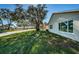 Side view of house with a large yard and mature tree at 4993 Bostonian Loop # 4993, New Port Richey, FL 34655