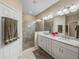 Bathroom boasts a glass-enclosed shower, dual sinks with granite counters, and neutral tones at 8916 Arabella Ln, Seminole, FL 33777
