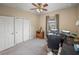 Bright bedroom featuring a ceiling fan, neutral walls, and a functional workspace with two monitors at 8916 Arabella Ln, Seminole, FL 33777