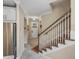 Entryway features tiled floor, front door, staircase with carpet runner, and stainless steel refrigerator at 8916 Arabella Ln, Seminole, FL 33777