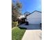 Daytime view of home's exterior with a two-car garage, walkway, and nicely landscaped front yard at 8916 Arabella Ln, Seminole, FL 33777