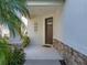 Welcoming front porch with stone accents and stylish light fixture for curb appeal at 8916 Arabella Ln, Seminole, FL 33777