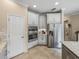 Bright kitchen features stainless steel appliances, white cabinetry, and neutral tile flooring at 8916 Arabella Ln, Seminole, FL 33777