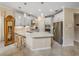 Kitchen with gray cabinets, an island with barstool seating, stainless steel appliances, and tile backsplash at 8916 Arabella Ln, Seminole, FL 33777