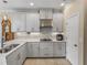 Kitchen with gray cabinets, stainless steel range hood, tile backsplash and a gas cooktop at 8916 Arabella Ln, Seminole, FL 33777