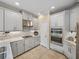 Kitchen features gray cabinets, stainless steel appliances, mosaic tile backsplash, and gas cooktop at 8916 Arabella Ln, Seminole, FL 33777