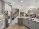 Kitchen features gray cabinets, stainless steel appliances, tile backsplash and a center island with sink at 8916 Arabella Ln, Seminole, FL 33777